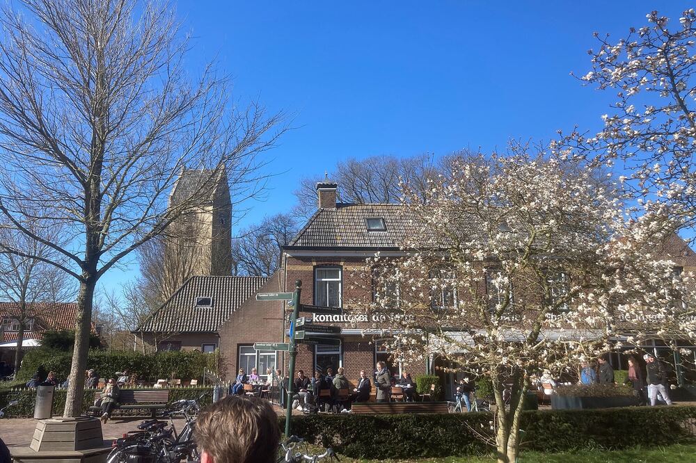 Het dorpsplein van Nes op Ameland met terrassen en de eeuwenoude toren