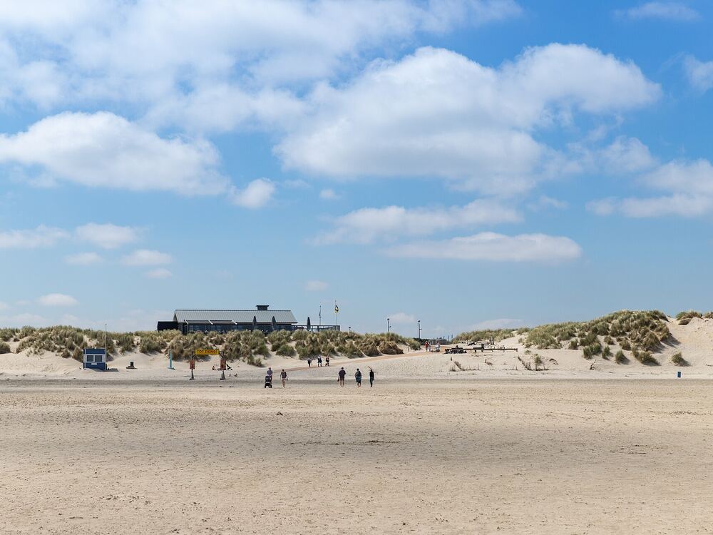 Het brede Noordzeestrand van Ameland met duinen en strandpaviljoen